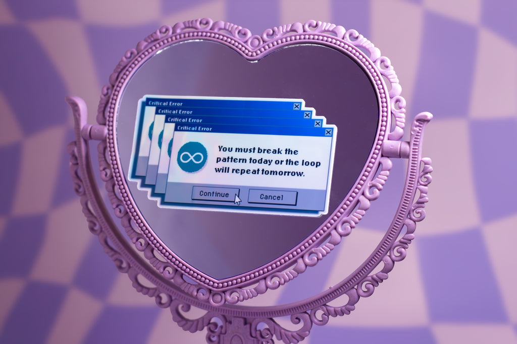 A lavender heart-shaped ornate mirror on a matching patterned background, reflecting a blue computer dialog box with text about breaking a pattern.