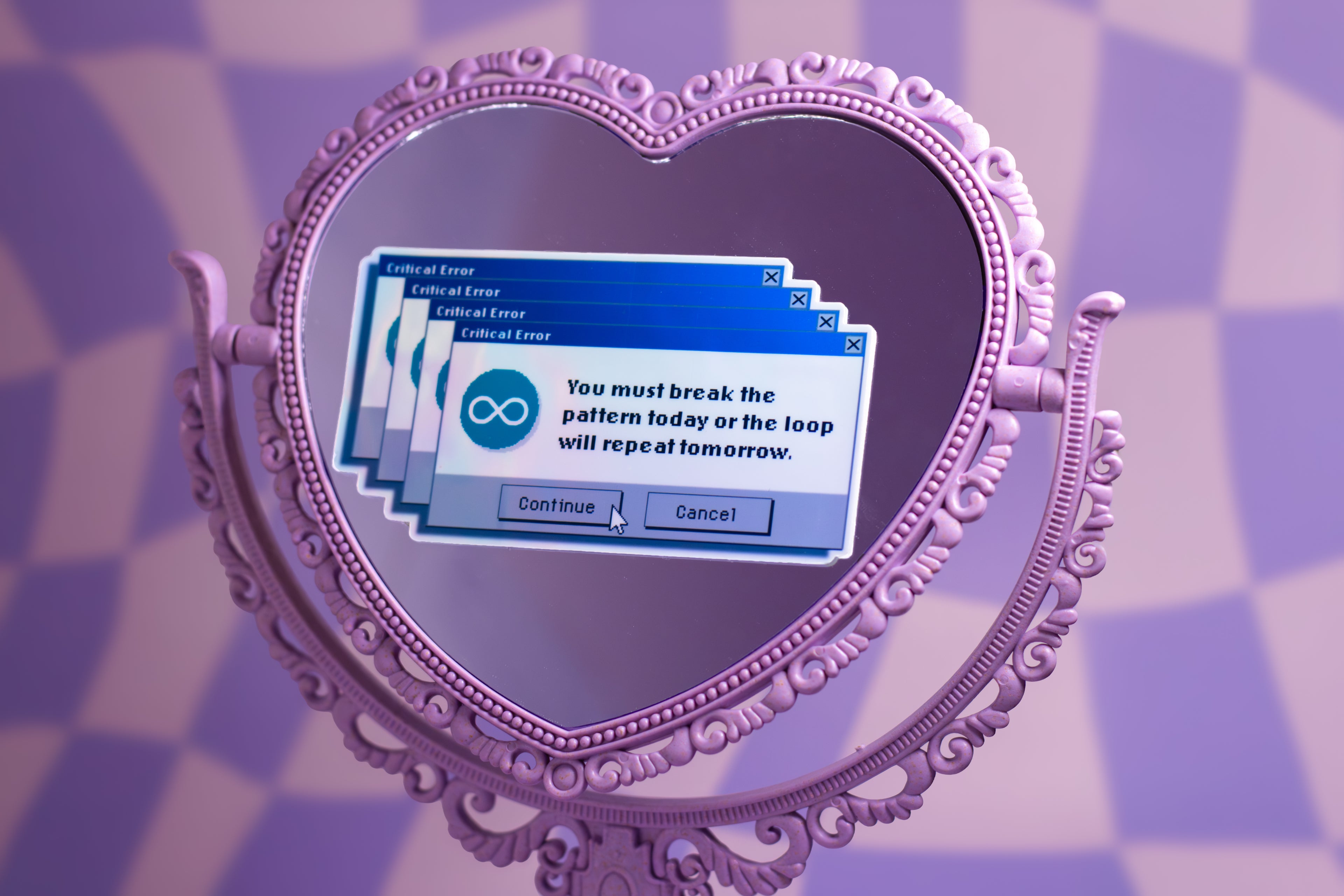 A lavender heart-shaped ornate mirror on a matching patterned background, reflecting a blue computer dialog box with text about breaking a pattern.